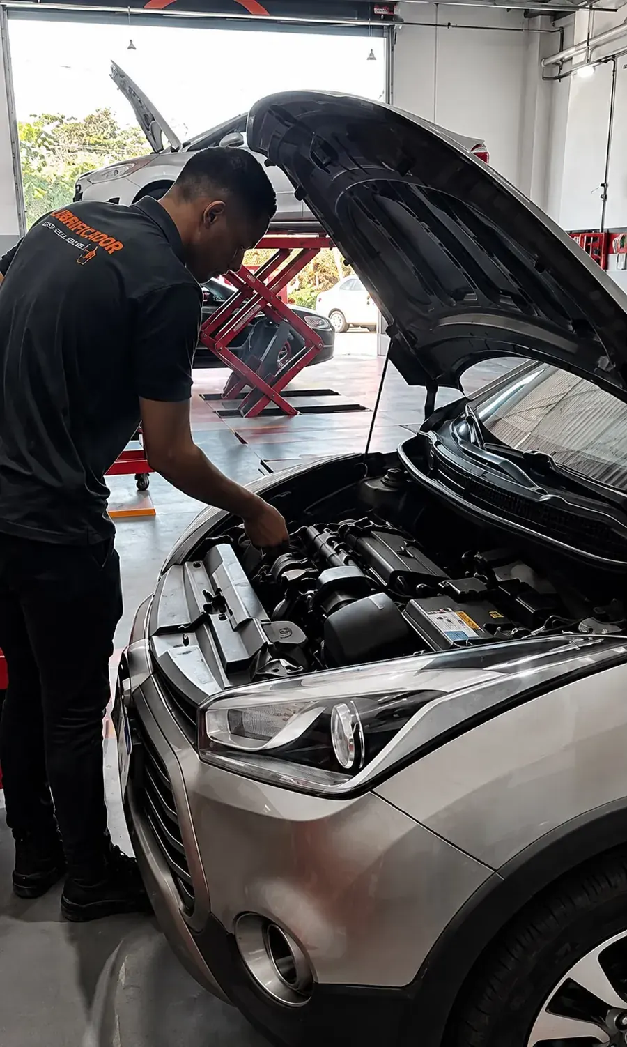Profissional da Mestre Lubrificador inspecionando o motor de um veículo